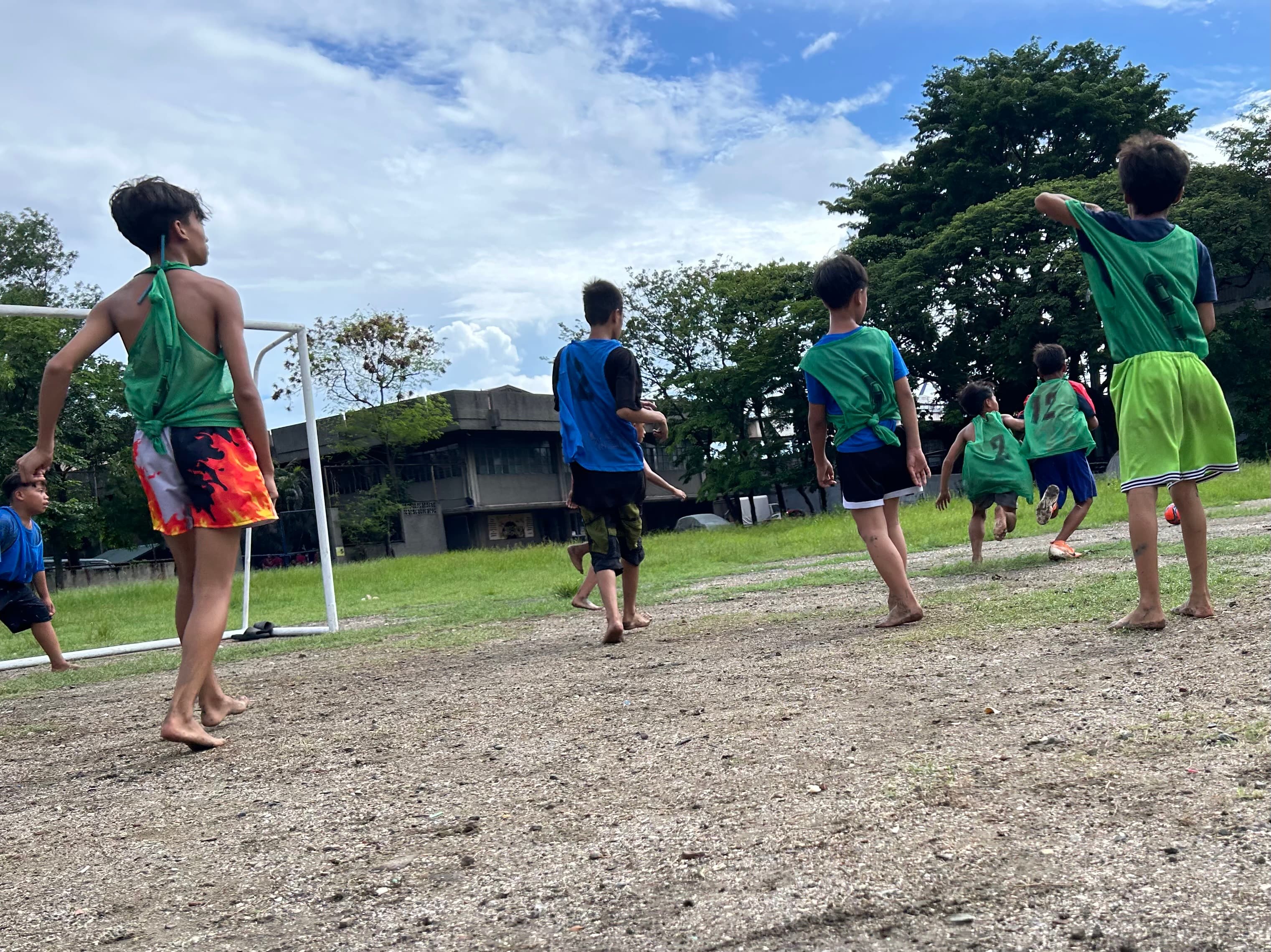 裸足でサッカーに参加する子どもたち